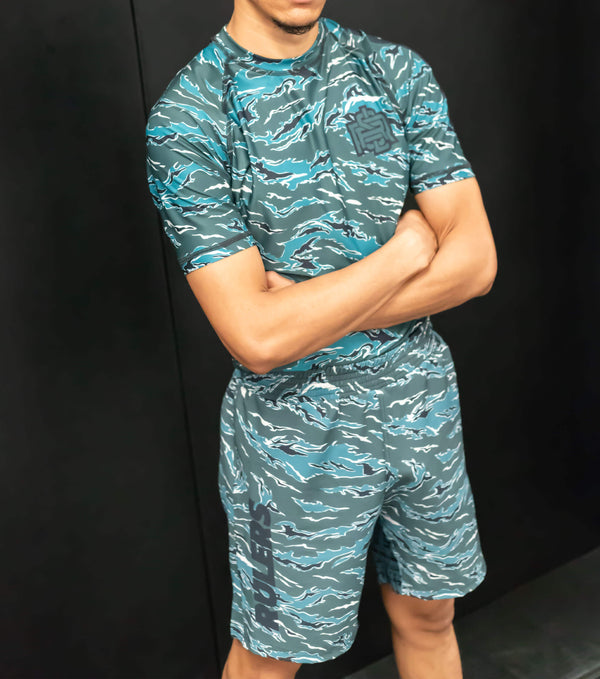 Athlete wearing RULERS Tiger Camo Green rashguard, displaying agility and technique during a training session, with a bold tiger camouflage design.
